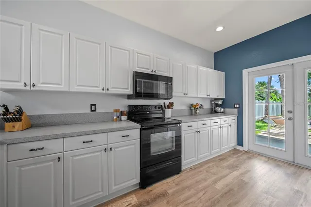 a kitchen with granite countertop white cabinets and appliances