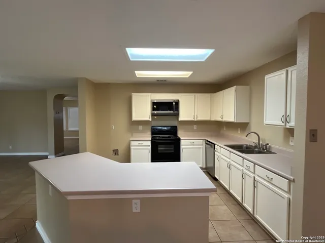 a kitchen with a sink cabinets and window