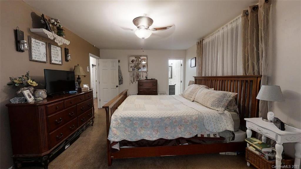 228 Huffstetler Lake Road Dallas, NC 28034 - Photo 22 of 27 a bedroom with a bed and a television