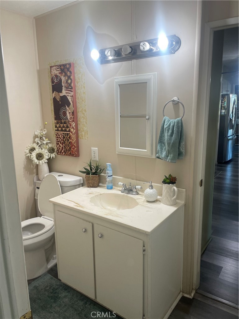 300 North Rampart Street, Unit 157 Orange, CA 92868 - Photo 12 of 14 a bathroom with a toilet sink and mirror
