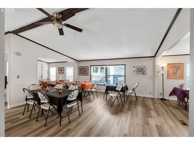 a kitchen with stainless steel appliances granite countertop a refrigerator a sink dishwasher a stove and white countertops with wooden floor