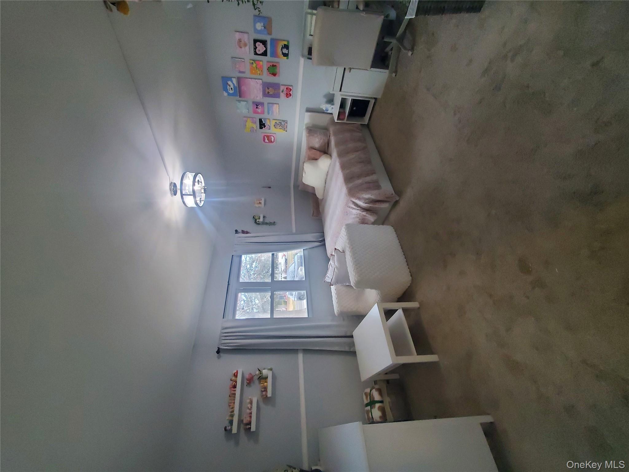 117 North Coleman Road Centereach, NY 11720 - Photo 11 of 29 a bedroom with a bed and a chandelier