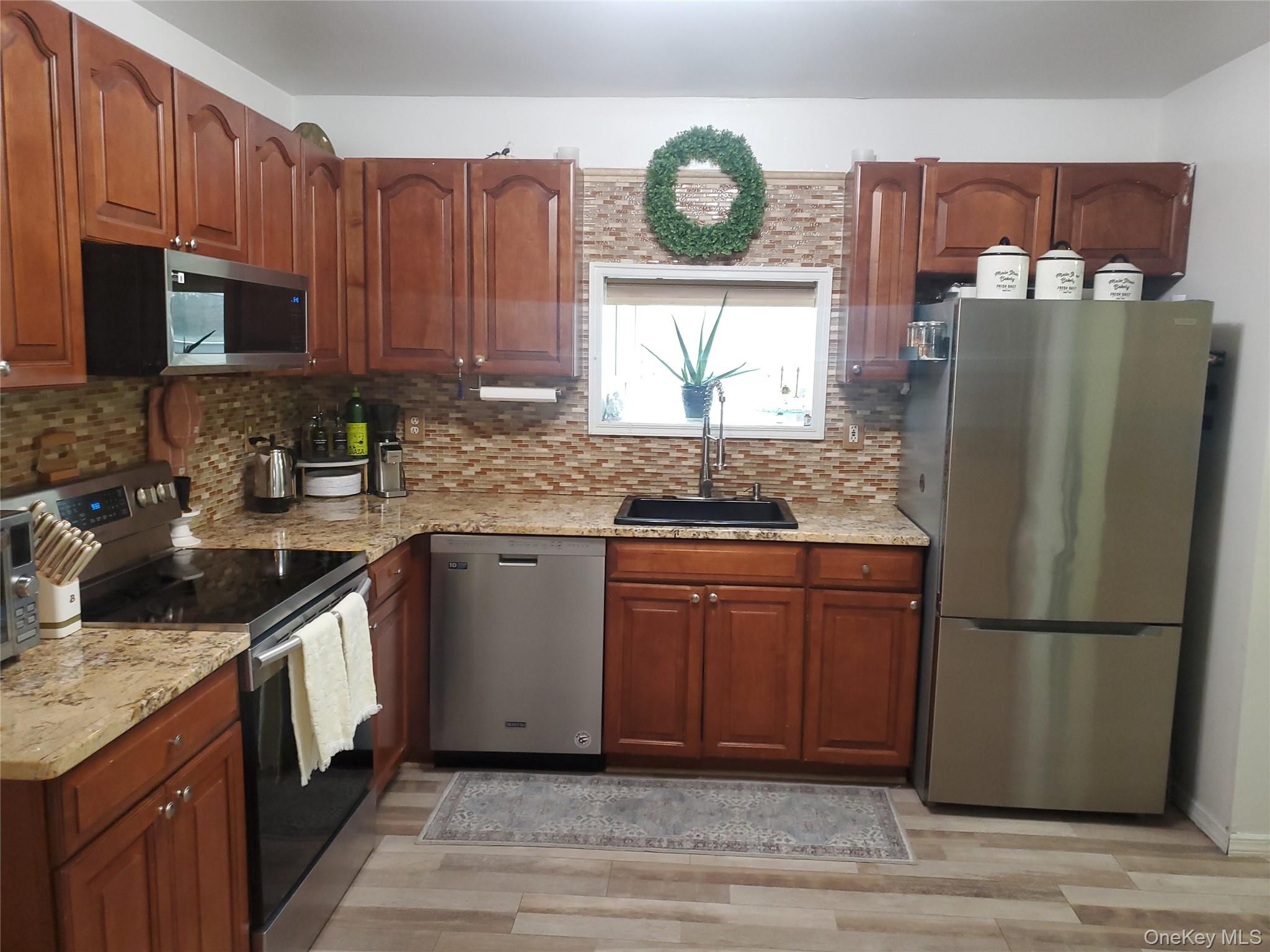 117 North Coleman Road Centereach, NY 11720 - Photo 4 of 29 a kitchen with stainless steel appliances granite countertop a refrigerator a stove a sink and a microwave