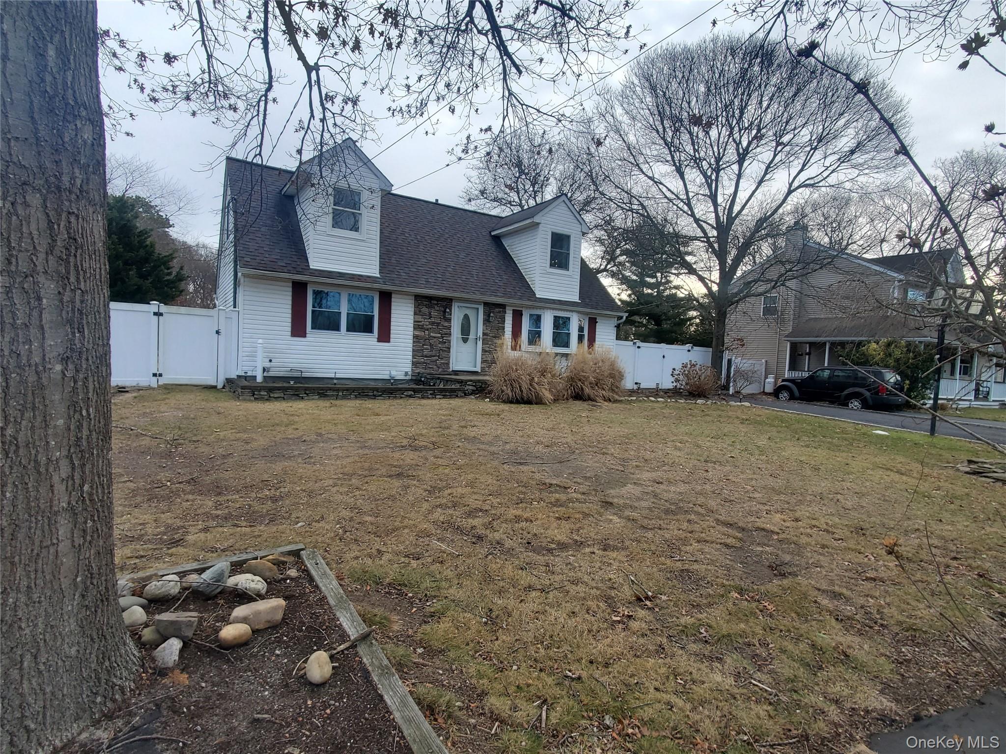 117 North Coleman Road Centereach, NY 11720 - Photo 4 of 26 Cape cod house with a gate, roof with shingles, and stone siding