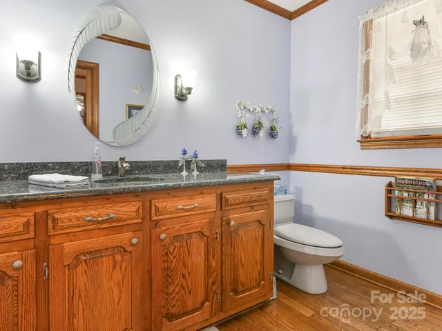 a bathroom with a granite countertop toilet sink and mirror