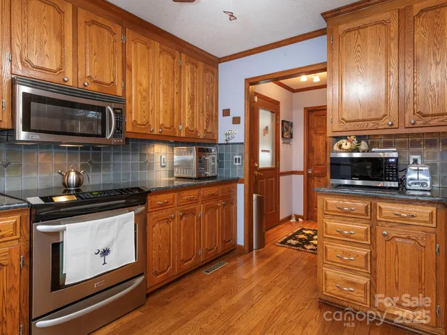 a kitchen with stainless steel appliances granite countertop a refrigerator stove top oven a sink and dishwasher