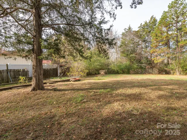a backyard of a house with lots of green space and trees
