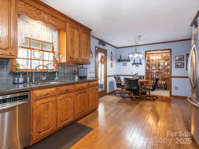 a kitchen with granite countertop dining table chairs cabinets and stainless steel appliances