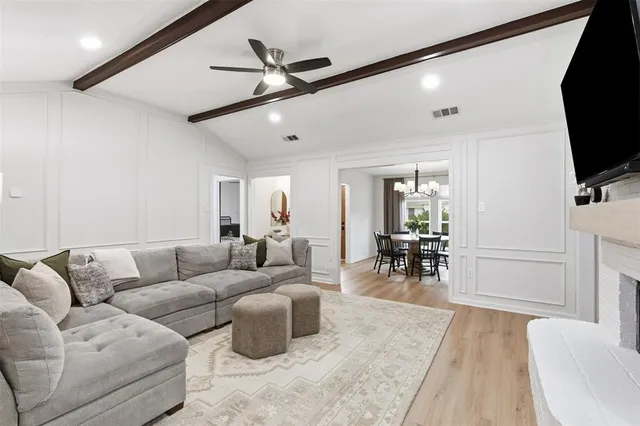 a dining room with wooden floor a chandelier a wooden table and chairs