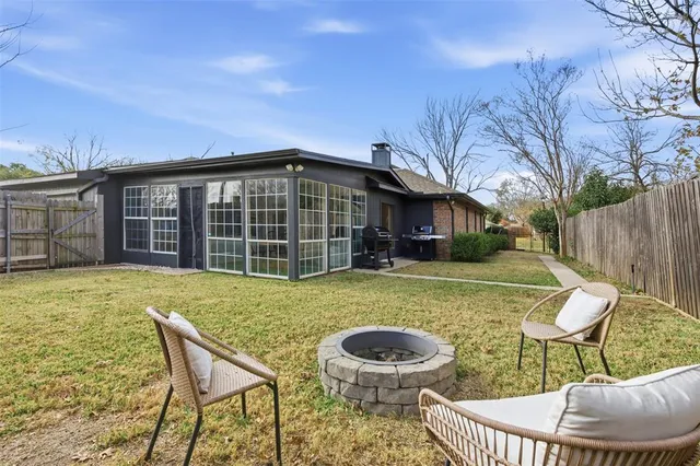 a view of back yard with table and chairs and wooden fence
