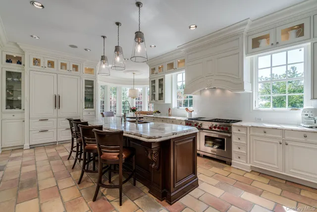 a kitchen with stainless steel appliances granite countertop a stove a sink a dining table and chairs