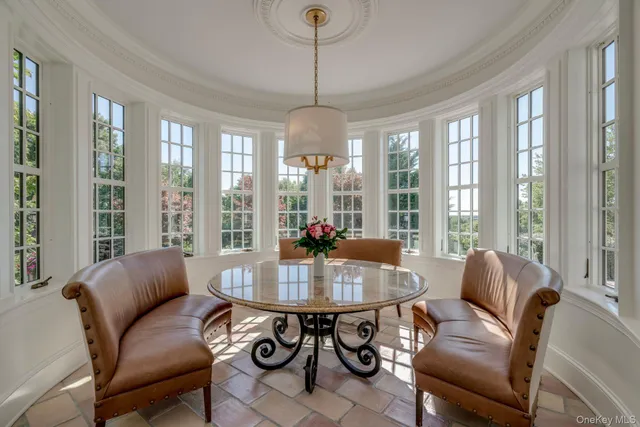 a dining hall with stainless steel appliances kitchen island granite countertop a table and chairs