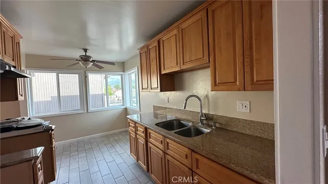 a kitchen with stainless steel appliances granite countertop a sink a stove cabinets and wooden floor