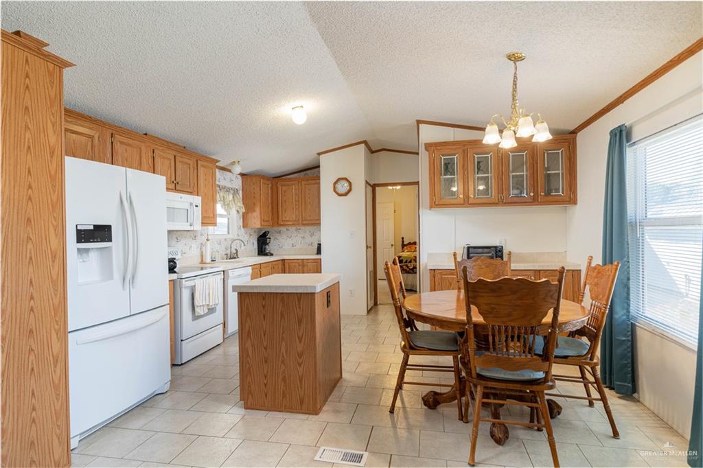 2004 Vernon Avenue Mission, TX 78572 - Photo 7 of 20 a kitchen with refrigerator cabinets dining table and chairs