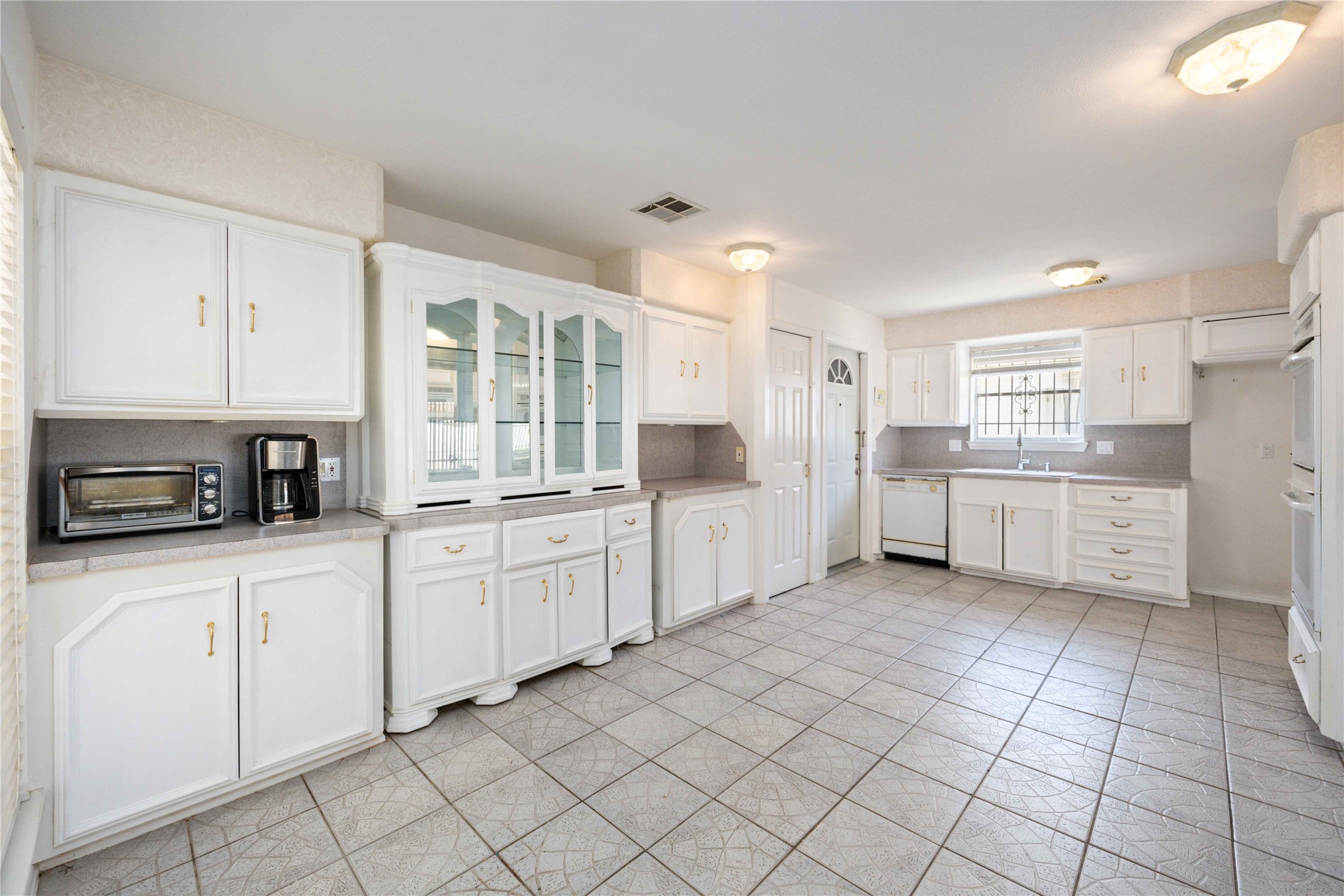 3910 Brookston Street Houston, TX 77045 - Photo 13 of 29 a kitchen with white cabinets a sink and white appliances