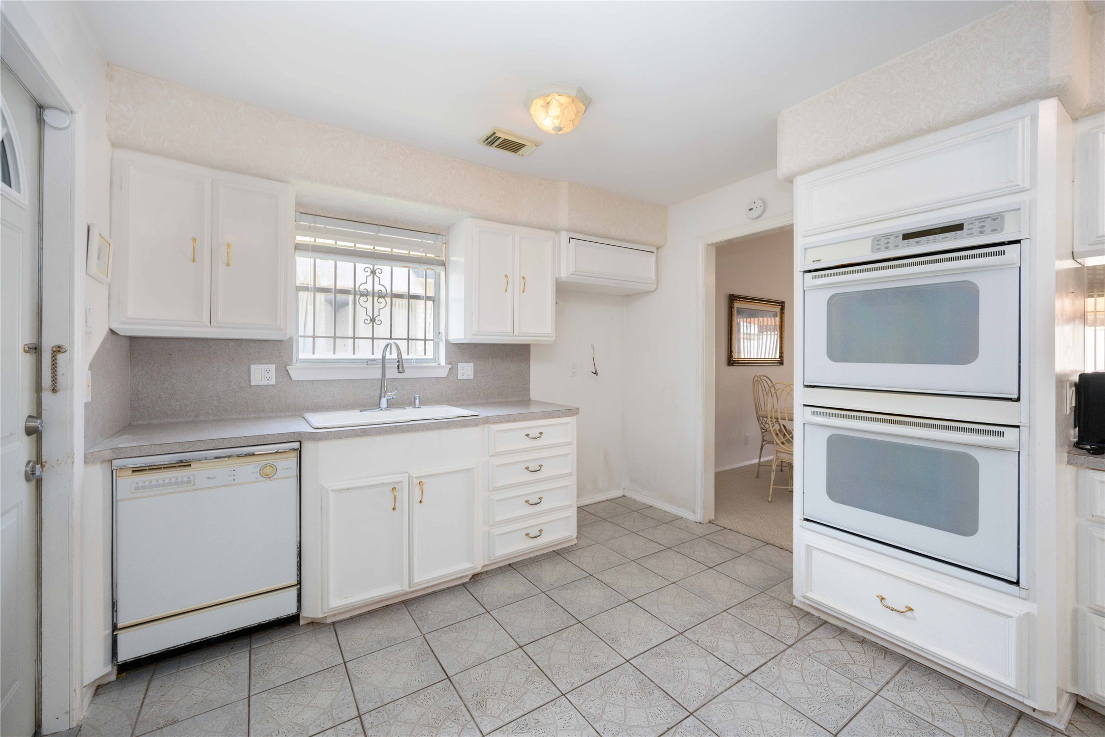 3910 Brookston Street Houston, TX 77045 - Photo 14 of 29 a kitchen with white cabinets and white appliances
