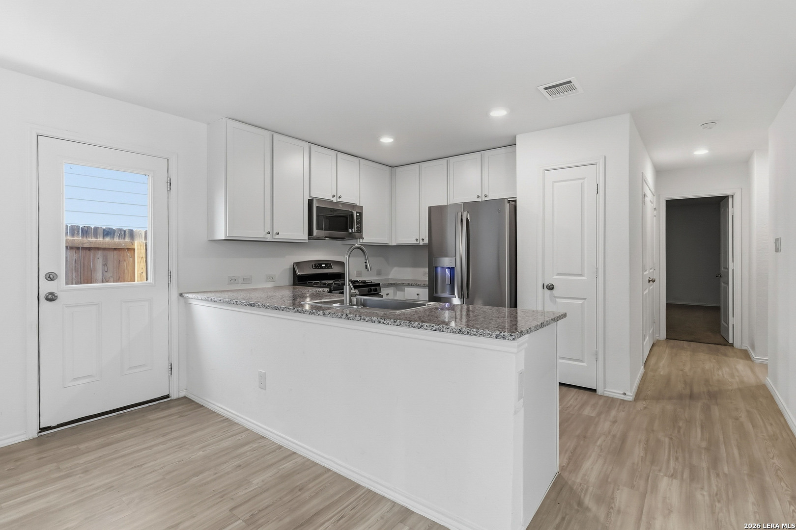 5155 Fowler Crest Converse, TX 78109 - Photo 8 of 20 a kitchen with stainless steel appliances granite countertop a refrigerator a stove top oven a sink and dishwasher with wooden floor