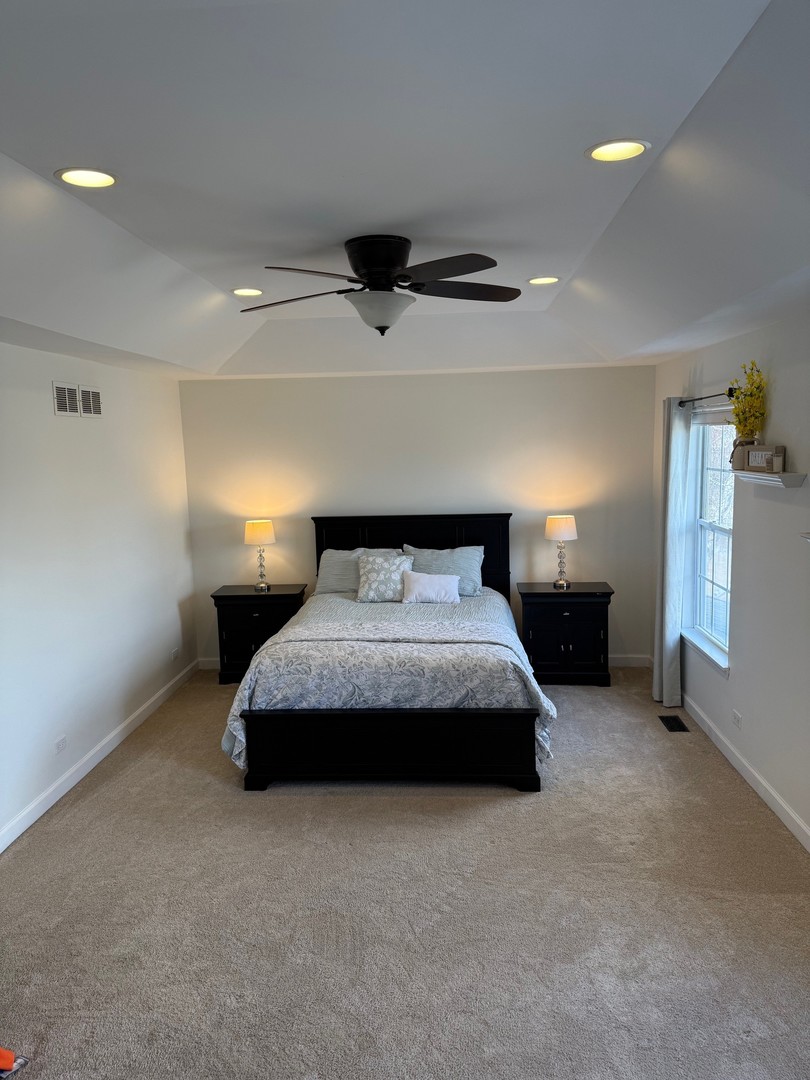 1785 Briggs Street Sycamore, IL 60178 - Photo 20 of 43 a spacious bedroom with a bed and a ceiling fan