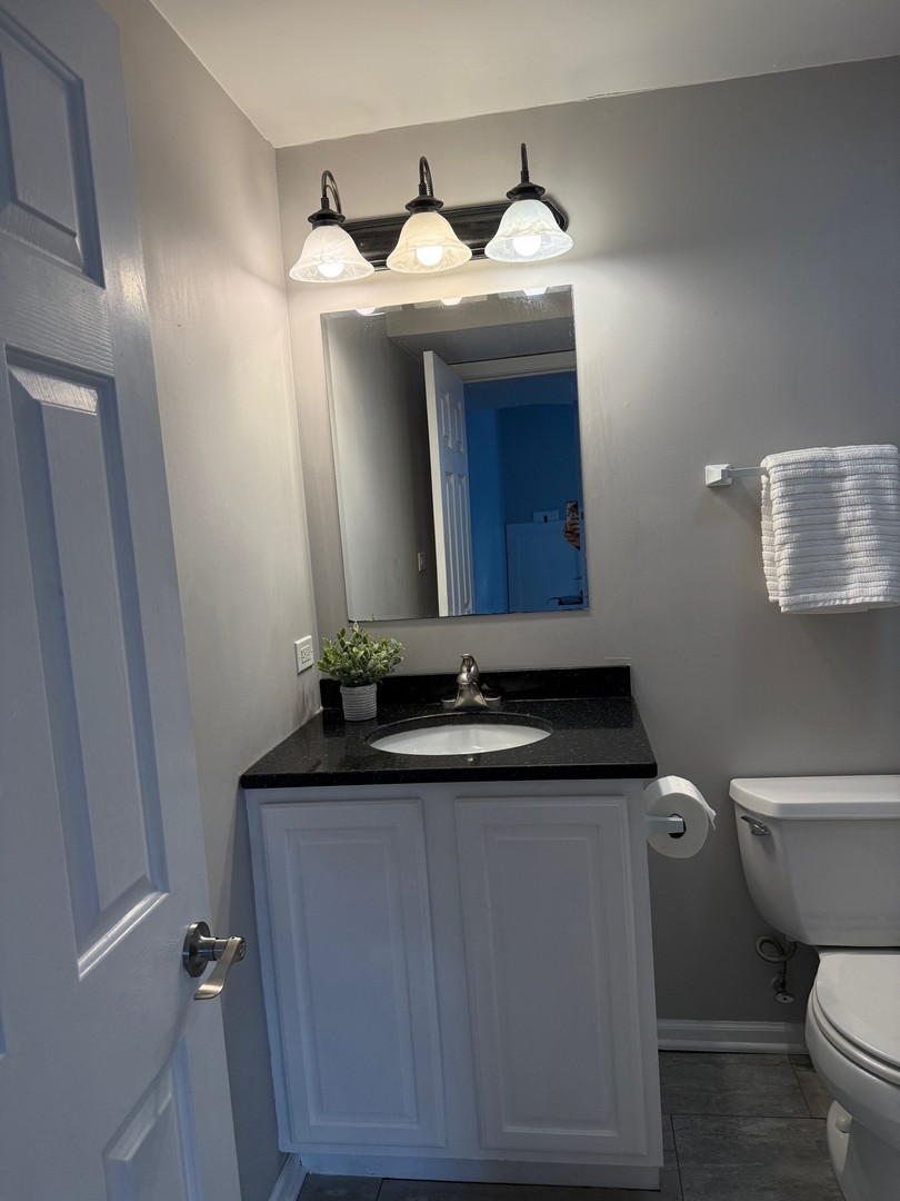 1785 Briggs Street Sycamore, IL 60178 - Photo 34 of 43 a bathroom with a granite countertop toilet sink and mirror