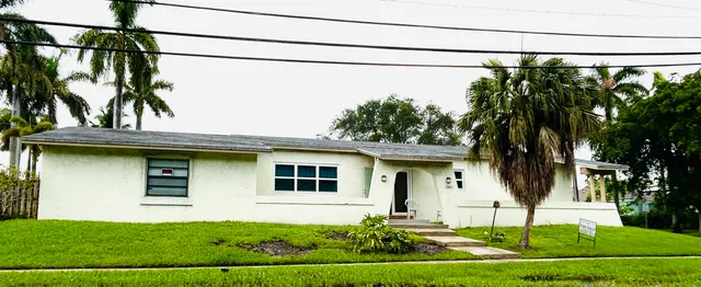 a view of a house with a yard and potted plants