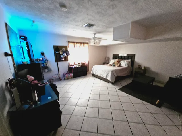 a spacious bedroom with a bed a couch and a window