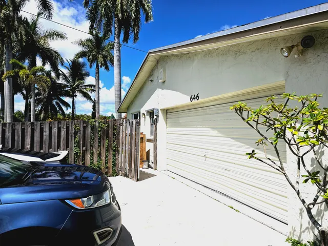 a view of a house with a yard and potted plants