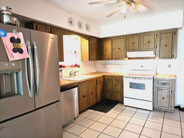 a view of a hallway with wooden floor and a bathroom