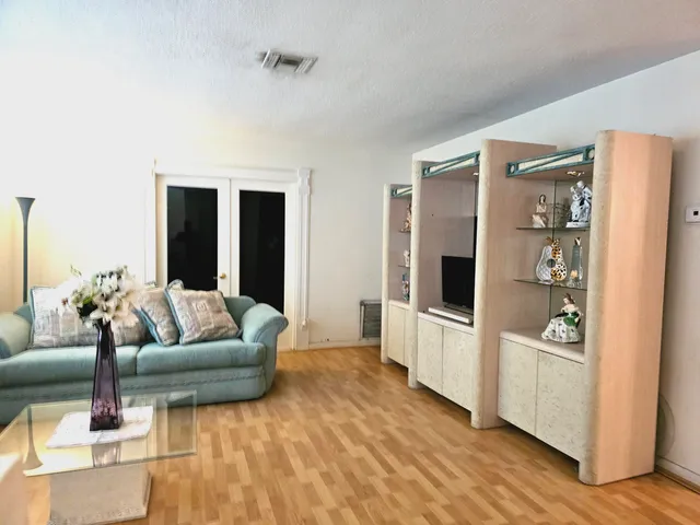 a living room with furniture and a refrigerator