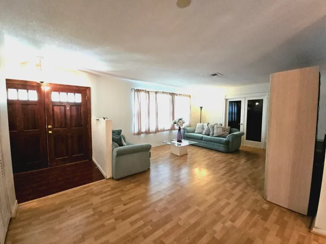 a room with a black white checkered floor with a gaming machine and glass table