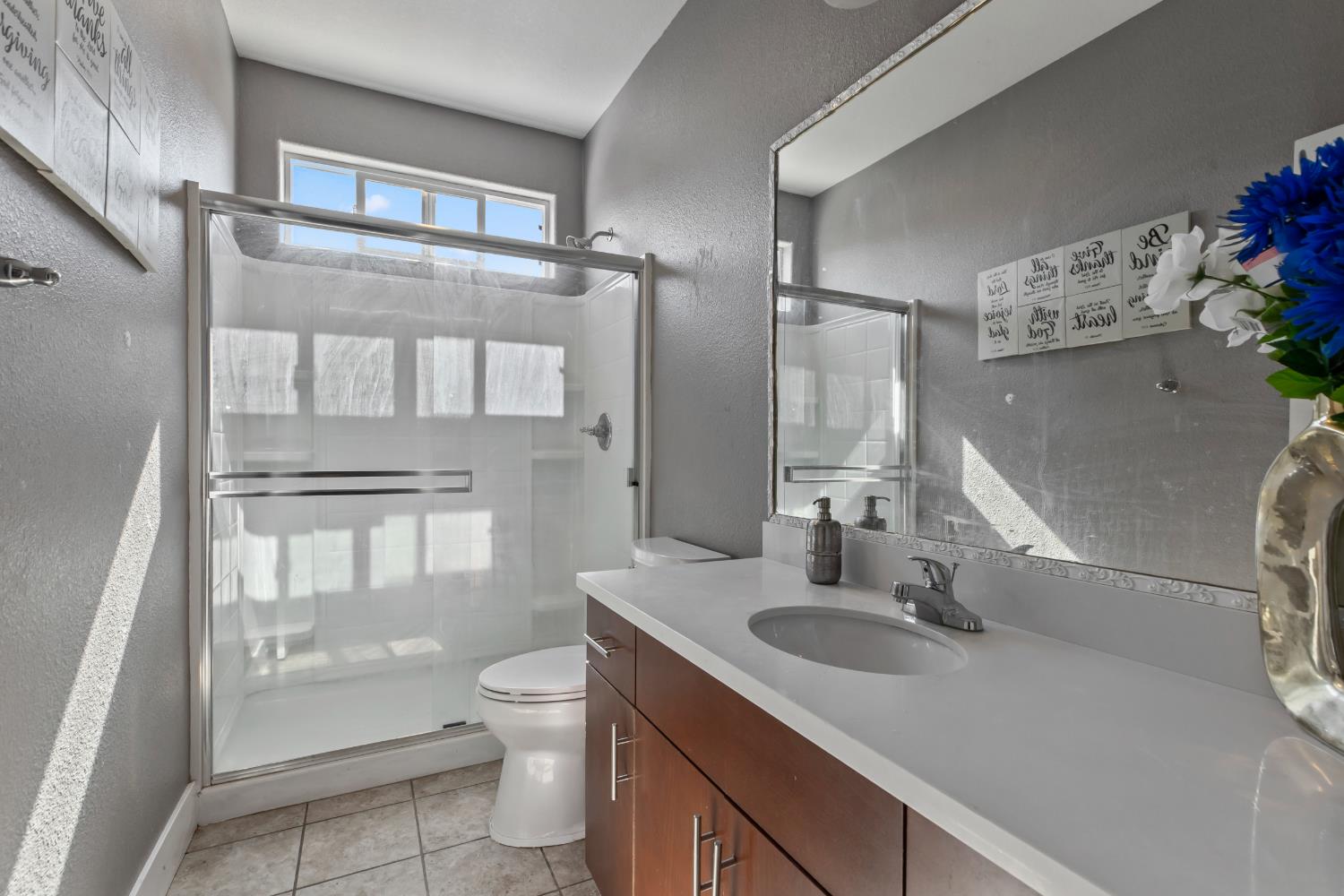 9423 Vintner Circle Patterson, CA 95363 - Photo 12 of 33 a bathroom with a sink toilet a mirror and shower