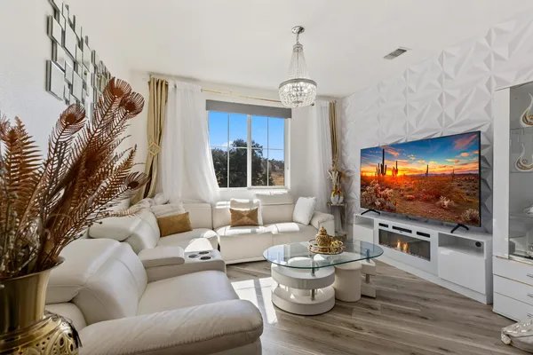 a living room with furniture a flat screen tv and kitchen view