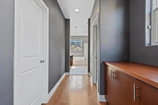 a view of a hallway with wooden floor and closet