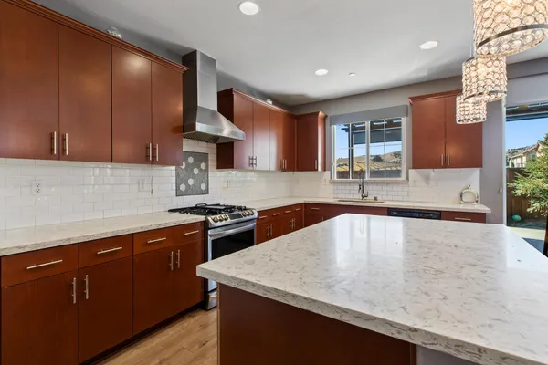 a kitchen with stainless steel appliances granite countertop a sink stove and cabinets
