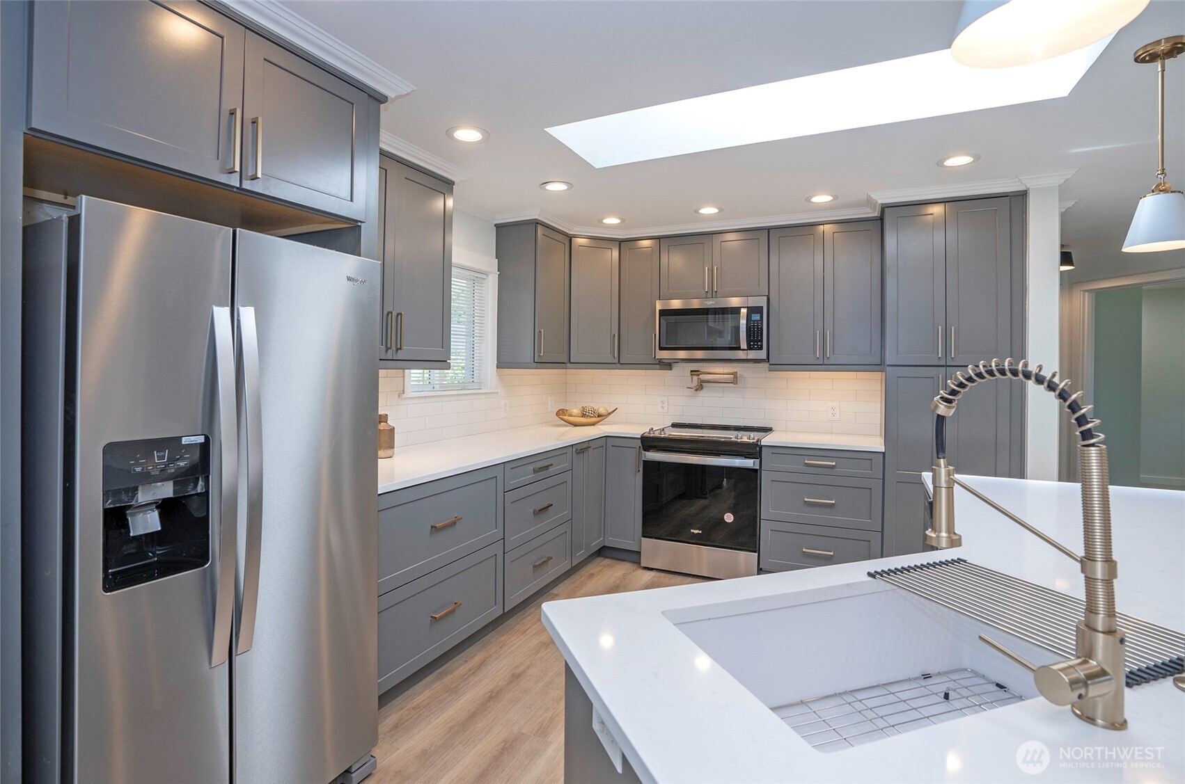15512 Elm Street East Sumner, WA 98390 - Photo 14 of 37 a large kitchen with stainless steel appliances kitchen island a stove a refrigerator a sink and a refrigerator