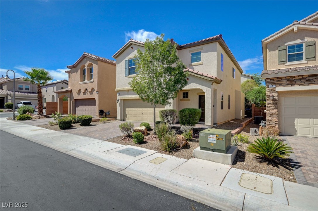 23 Lily Grove Road Las Vegas, NV 89148 - Photo 3 of 74 Mediterranean / spanish-style house featuring stucco siding, a residential view, a tiled roof, and driveway