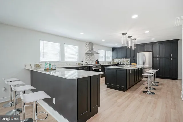 a kitchen with a sink a counter top space a large window and stainless steel appliances