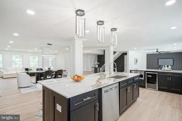 a kitchen with a stove a sink a kitchen island with chairs and wooden floor