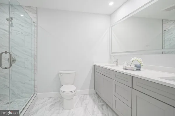 a bathroom with a granite countertop sink a toilet and a shower