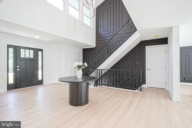a view of entryway with kitchen and hall with wooden floor