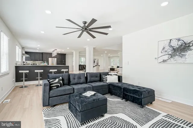 a living room with furniture and a view of kitchen