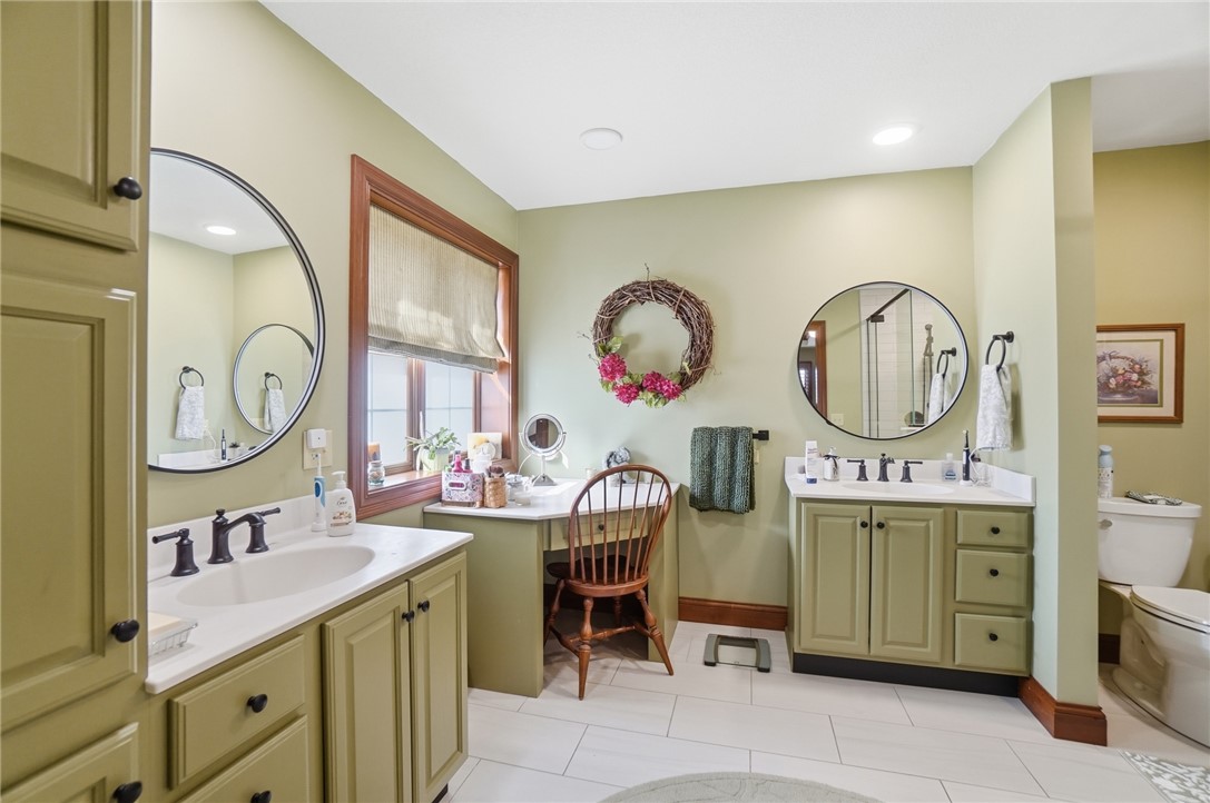 5300 Brookshire Lane Springfield, OH 45502 - Photo 29 of 56 This spacious bathroom offers dual vanities, an ample window, and a separate toilet area for comfort.
