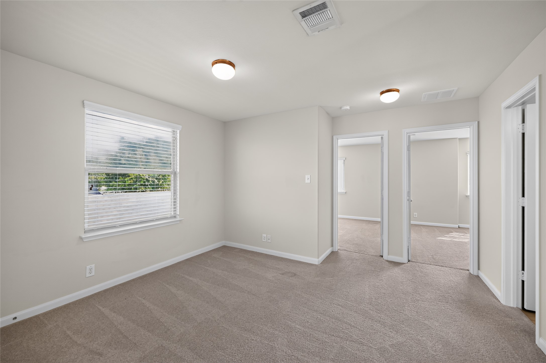 504 Old Peak Road Georgetown, TX 78626 - Photo 13 of 25 A well-lit room awaits with plush carpeting and natural light filtering through the window blinds.