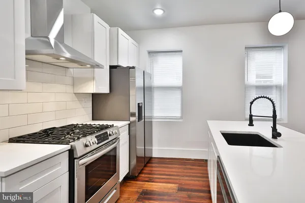 a kitchen with stainless steel appliances a stove a sink and a refrigerator
