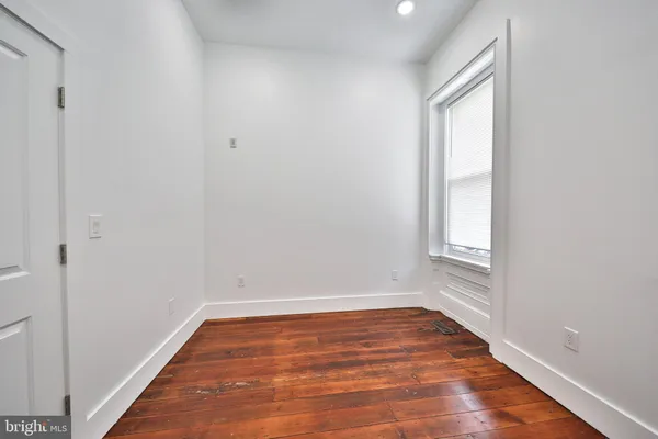 a view of room with window and wooden floor