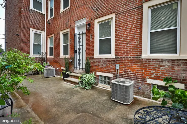 a view of a door with a chairs and potted plants