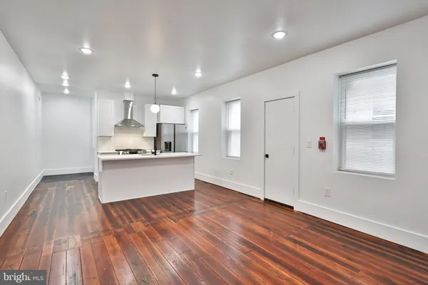 a view of kitchen with wooden floor and electronic appliances
