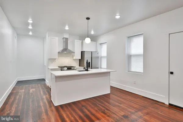 a kitchen with stainless steel appliances granite countertop a sink a stove and a wooden floors