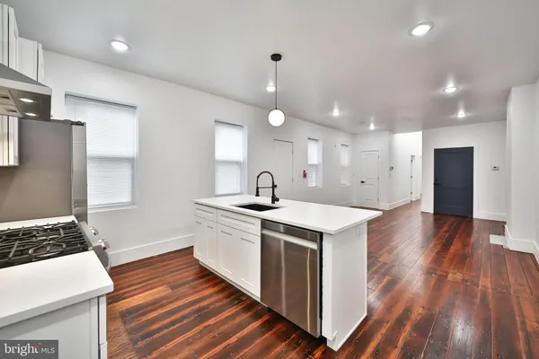a kitchen with wooden floor and white appliances