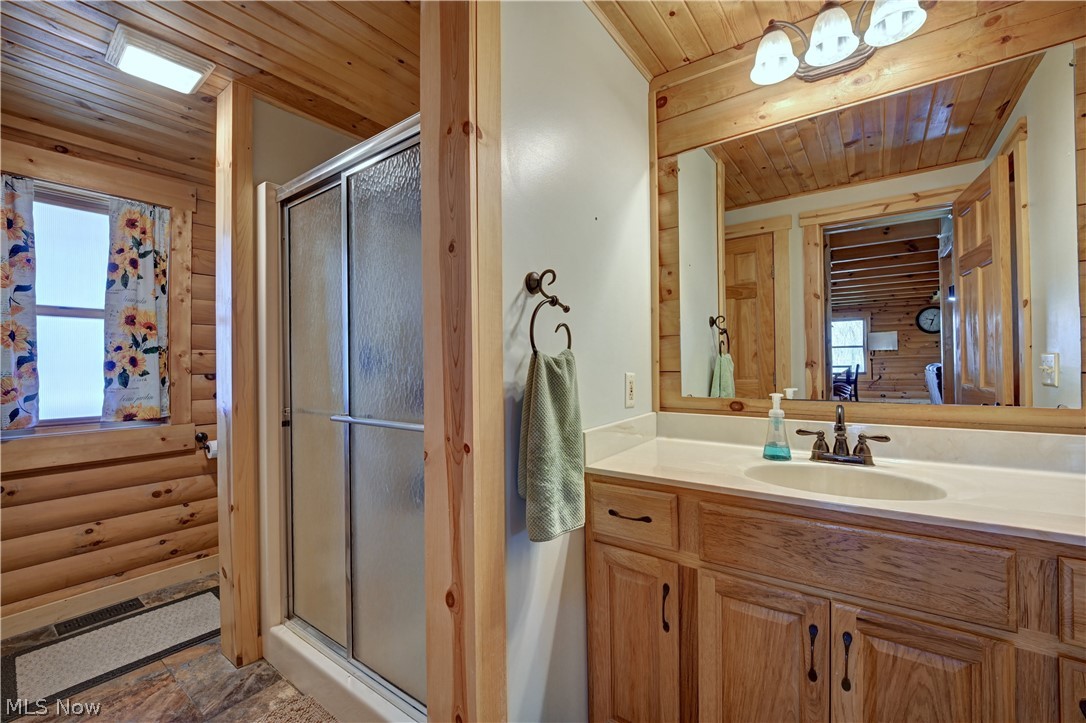 8045 McFadden Road Shreve, OH 44676 - Photo 30 of 45 Full bath with a shower stall, wooden ceiling, vanity, and log walls