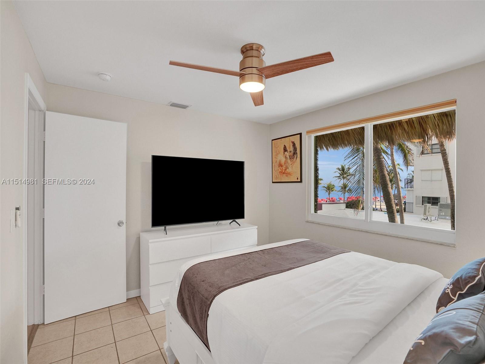 900 North Surf Road, Unit 2 Hollywood, FL 33019 - Photo 14 of 48 a bedroom with a bed and a flat screen tv